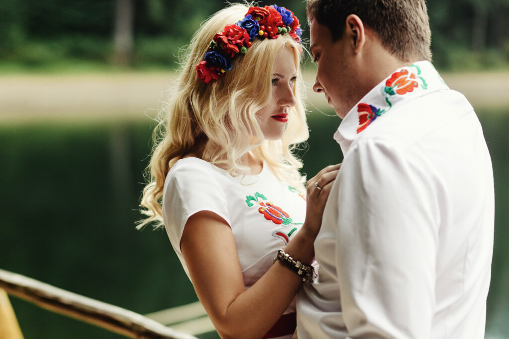 Man and woman lean to each other heads standing on wooden porch