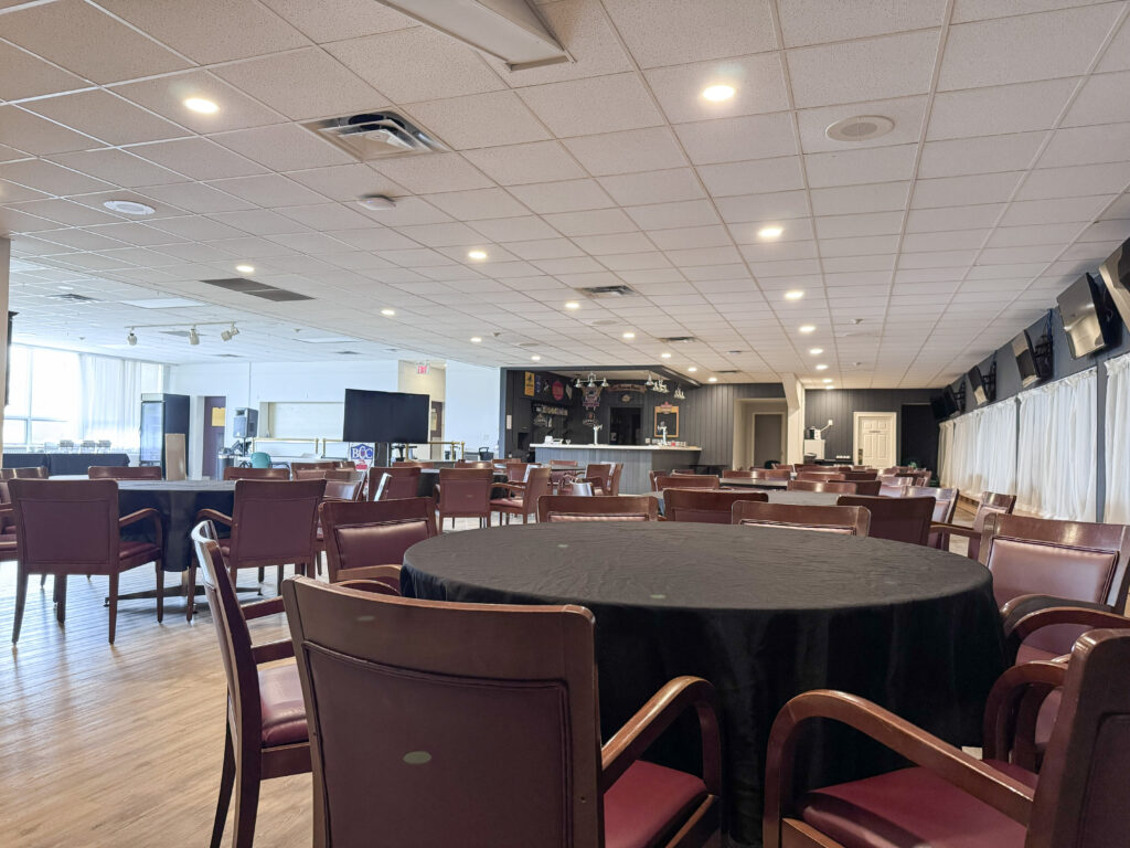 Main reception hall at the Barrie Curling Club with round tables set for a wedding Title: Barrie Curling Club Reception Hall — Wedding Venue Barrie Ontario