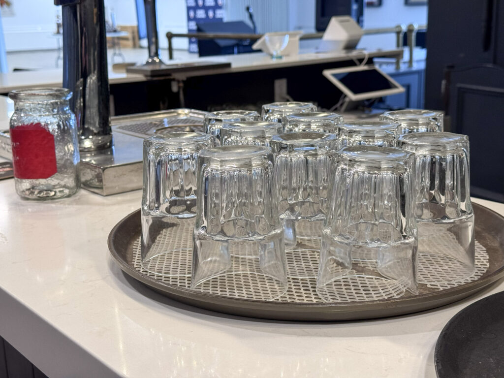 Bar area with hanging glassware at the Barrie Curling Club Title: Barrie Curling Club Bar — Wedding Reception Bar Service