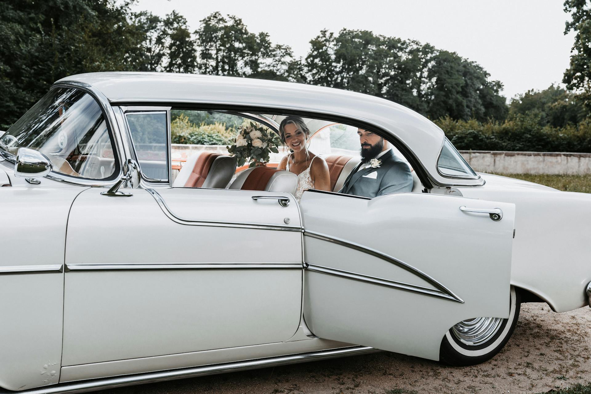 married couple in back of classic car