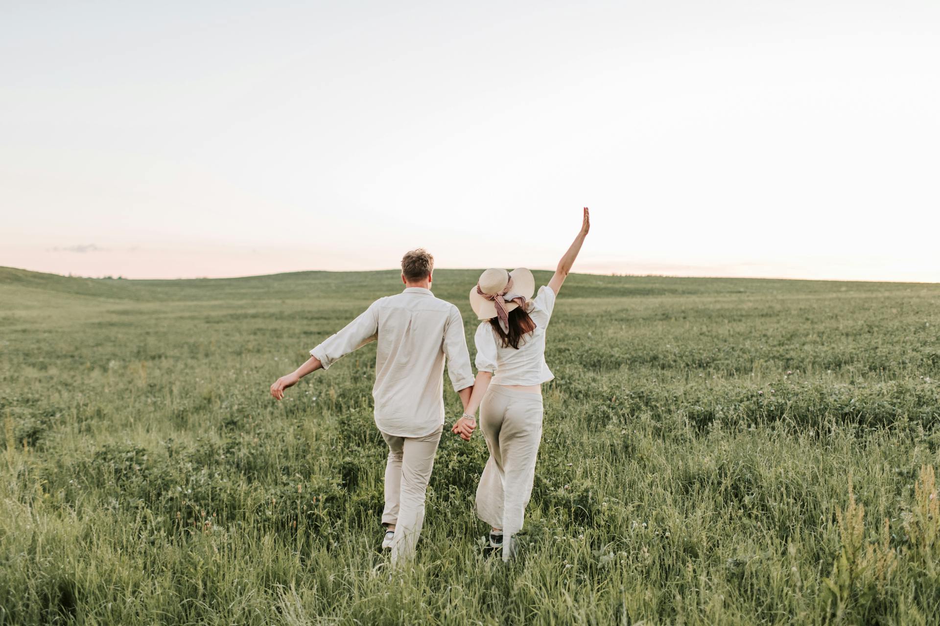 married couple running in field