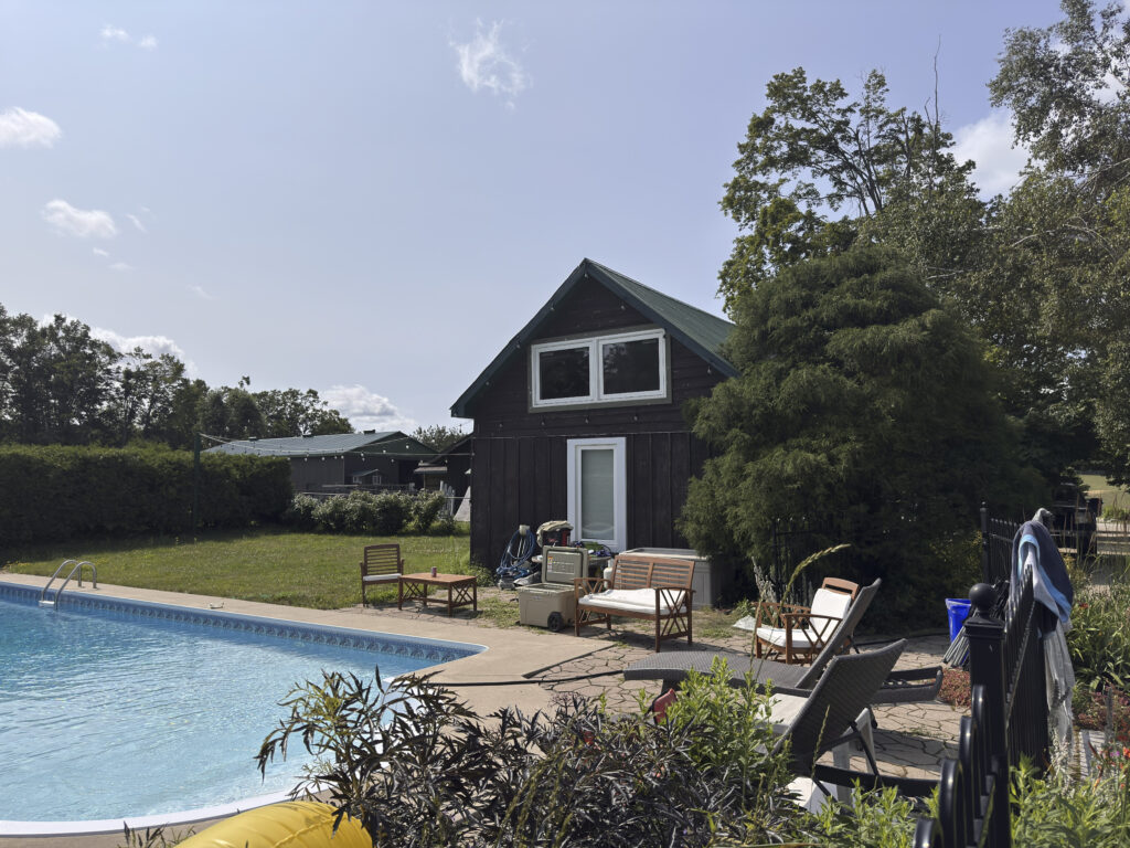 A building at Glen Oro Farm with an adjoining pool and patio seating