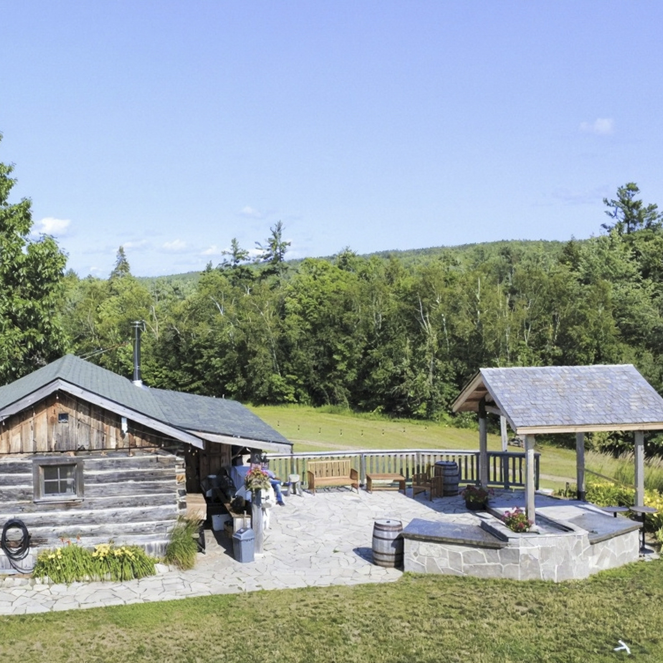 The little house at Glen Oro Farm overlooking a forested ridge, with covered patio seating for a small wedding gathering