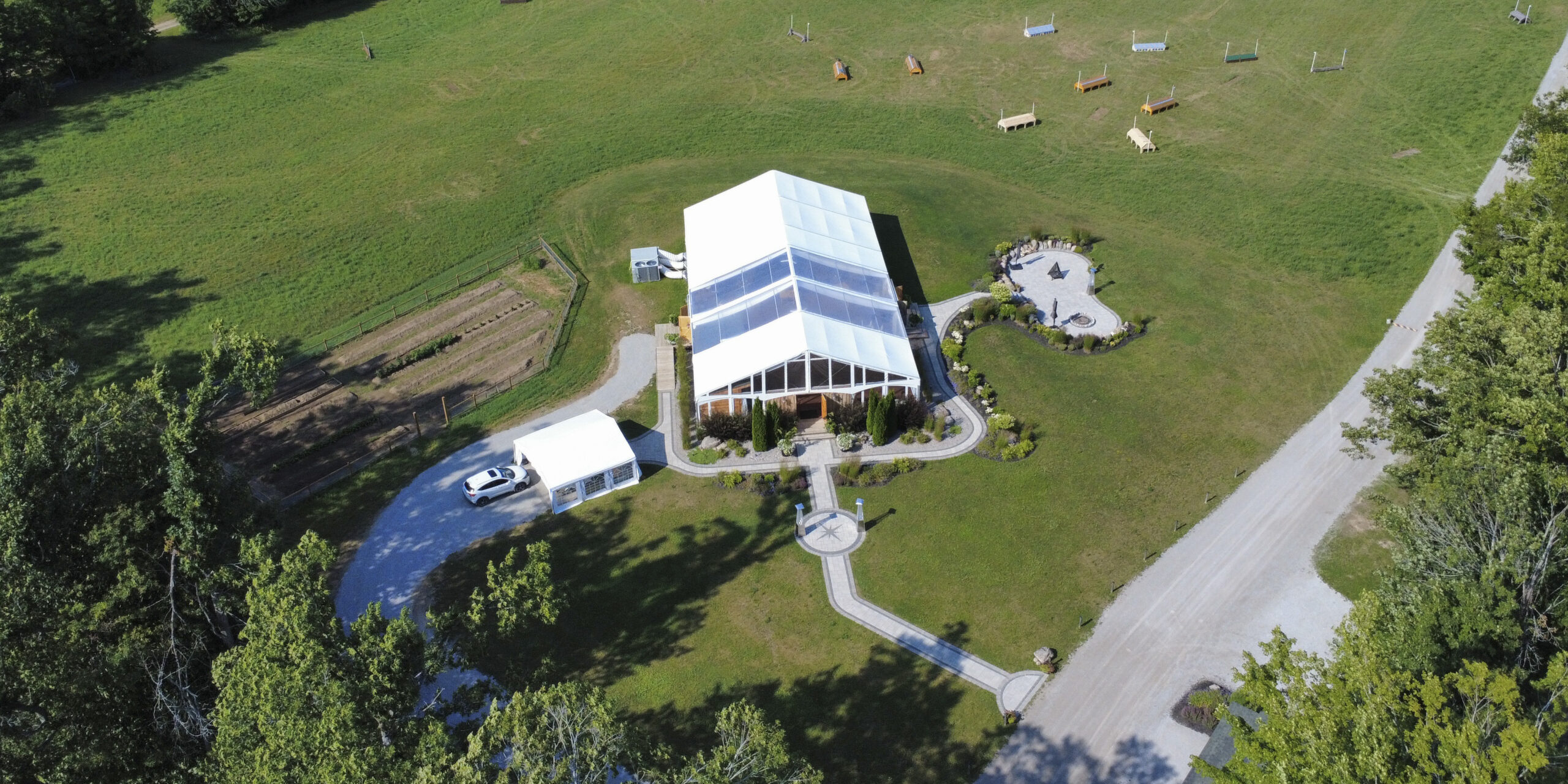 Aerial view of Glen Oro Farm's main hall and event grounds in Oro-Medonte, Ontario, showing the tent area, parking, and surrounding fields