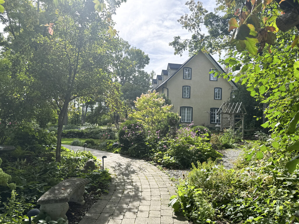 Paver path winding through gardens toward the historic farmhouse at Northbrook Farm