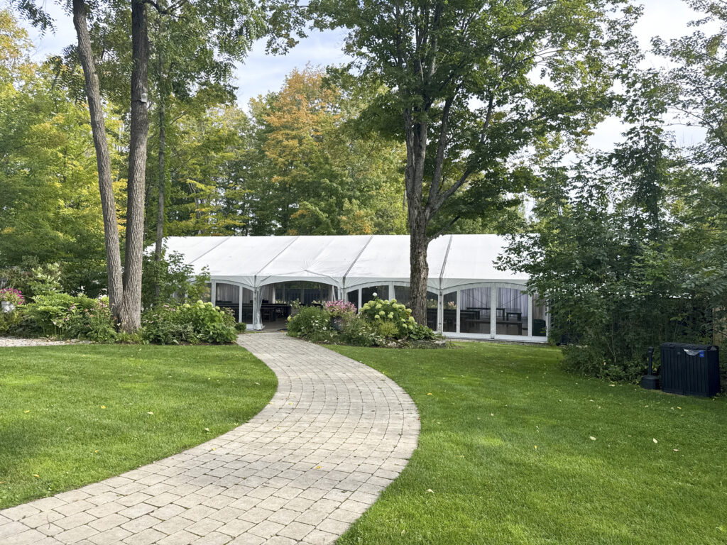 Curved paver walkway leading across the lawn to the white reception tent